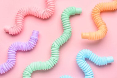 Pembe arka planda farklı renkli pop tüpleri