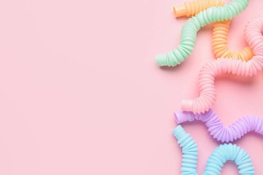 Pembe arka planda farklı renkli pop tüpleri