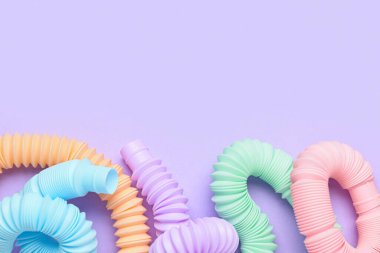 Mor arka planda farklı renkli pop tüpleri