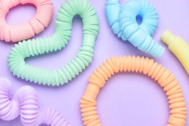 Mor arka planda farklı renkli pop tüpleri