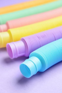 Mor arka planda farklı renkli pop tüpleri, yakın plan