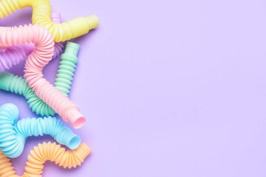 Mor arka planda farklı renkli pop tüpleri