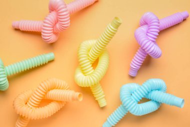 Turuncu arka planda farklı renkli pop tüpleri