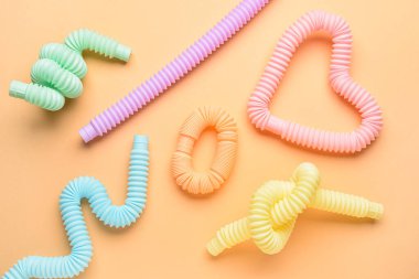 Turuncu arka planda farklı renkli pop tüpleri