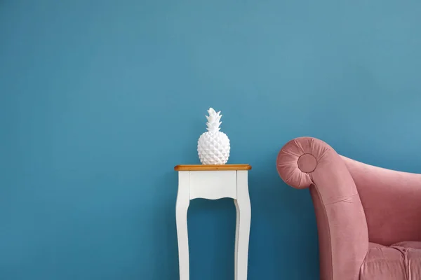 お部屋にはブルーの壁に近いテーブルと装飾的なパイナップルとスタイリッシュな快適なアームチェア — ストック写真