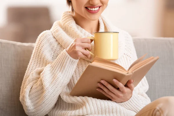 Young Woman Drinking Tasty Tea Reading Book Sofa Home — Stock Photo, Image