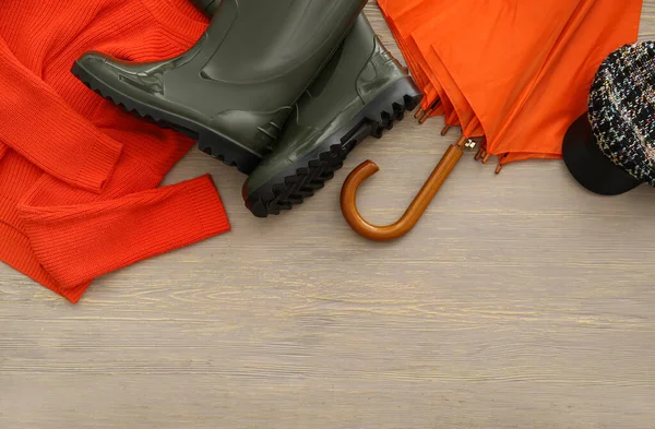 Umbrella Rubber Boots Sweater Cap Grey Wooden Background Closeup — 图库照片