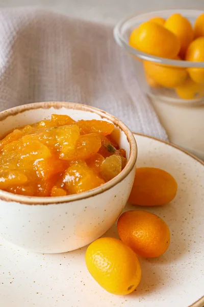 Bir kase lezzetli kumkat reçeli ve taze meyve.