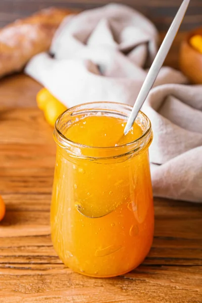 Ahşap arka planda lezzetli kumkuat reçeli kavanozu