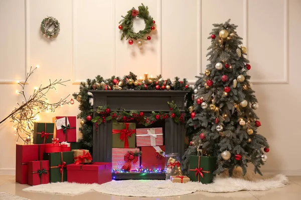 美しいリビングルームでクリスマスツリーと贈り物と暖炉を飾る — ストック写真