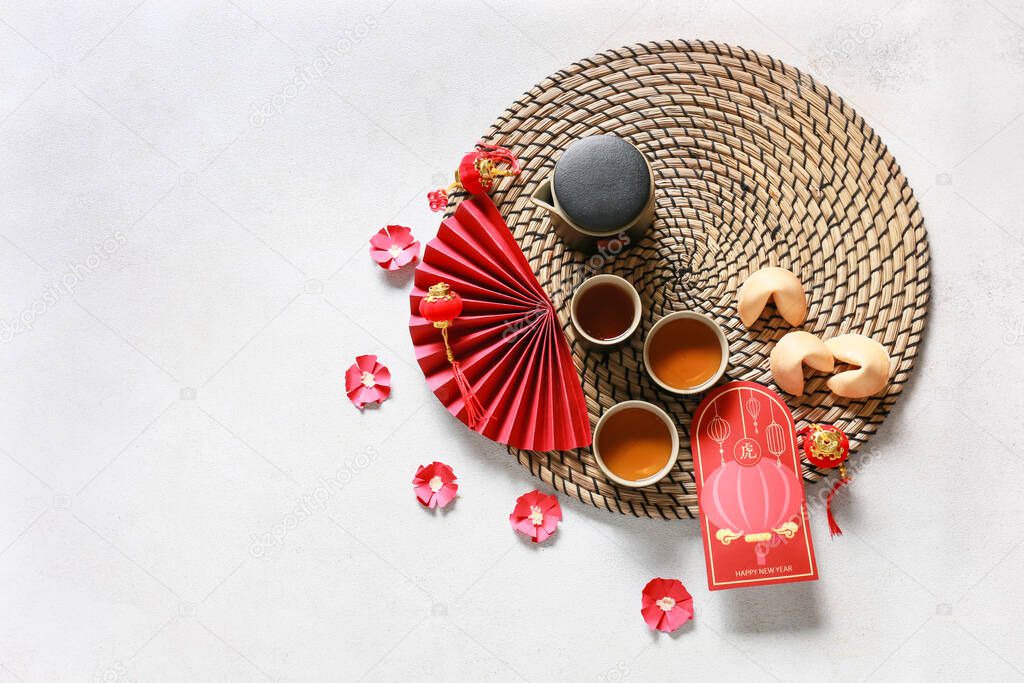 Red envelope with tea and Chinese symbols on light background. New Year celebration