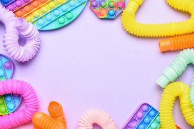 Renkli pop tüplerinden yapılmış çerçeve ve mor arka planda hareketli oyuncaklar