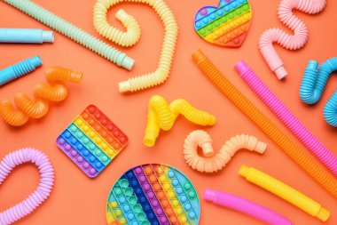 Renkli pop tüpleri ve turuncu arka planda hareketli oyuncaklar