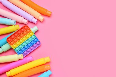 Renkli pop tüpleri ve pembe arka planda hareketli oyuncaklar