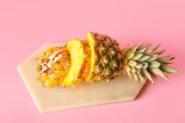 Pembe arka planda taze kesilmiş ananas tahtası