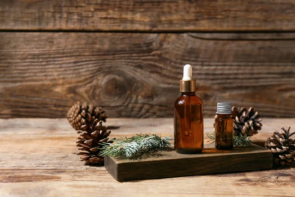 Board Bottles Essential Oil Fir Branch Pine Cones Wooden Background — Stock Photo, Image