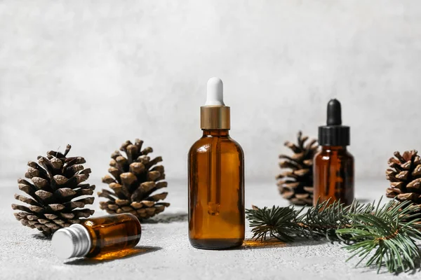 Bottles Essential Oil Fir Branch Pine Cones Light Background — Stock Photo, Image