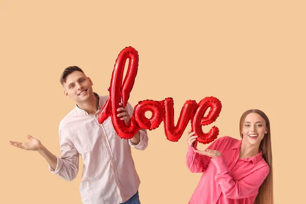 Junges Paar Mit Luftballon Form Von Wort Liebe Auf Farbigem — Stockfoto