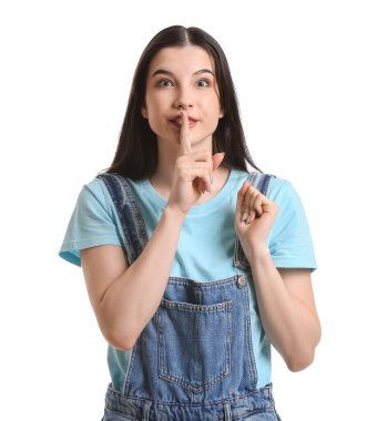 Beyaz arka planda sessizlik hareketi gösteren genç bir kadın.