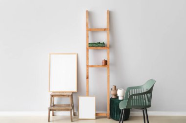 Merdivende boş poster ve ışık duvarının yanında dekor var.