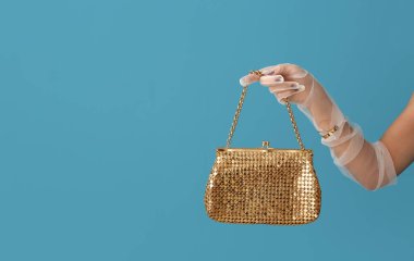 Şık eldivenleri ve renkli çantaları olan zarif genç bir kadının eli.