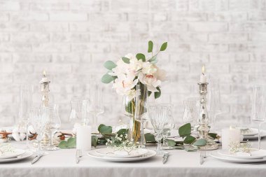 Bej tuğla duvarın yanında düğün için güzel bir masa.