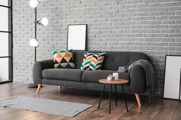 Sofa Gelap Bergaya Dengan Poster Kosong Dekat Dinding Bata — Stok Foto