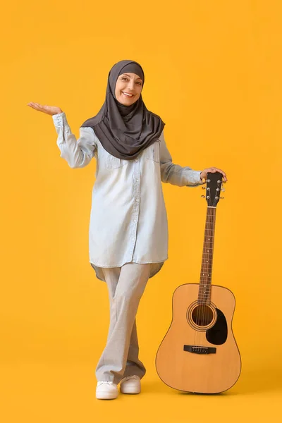具有彩色背景吉他的穆斯林音乐教师 — 图库照片