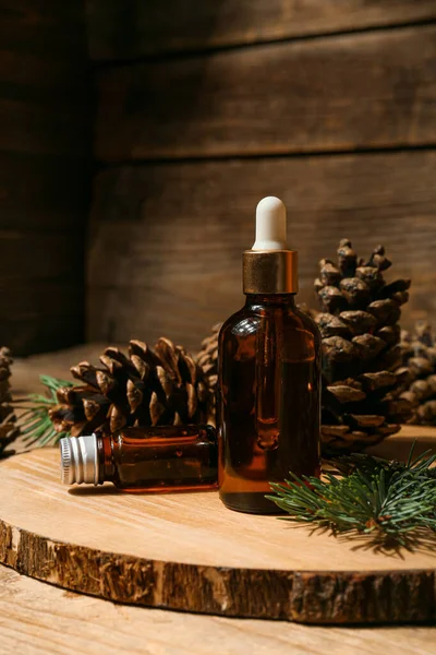 Board Bottles Essential Oil Pine Cones Wooden Background Closeup — Fotografia de Stock