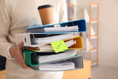 Ofiste belgelerle çalışan genç adam, yakın plan.