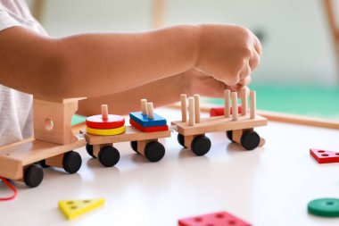 Masada tahta oyuncaklarla oynayan sevimli küçük çocuk, yakın plan.