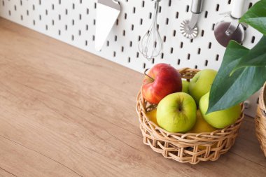 Mutfaktaki masanın üstünde elmalar olan sepet.