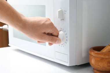 Mutfakta modern mikrodalga fırını ayarlayan kadın, yakın plan.