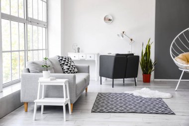 Beyaz basamaklı iskemle ve kanepeli oturma odasının içi.