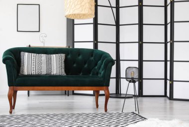 Yeşil kanepe ve lambalarla aydınlık oturma odasının içinde.