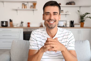 Yakışıklı adam evde görüntülü sohbet ediyor.