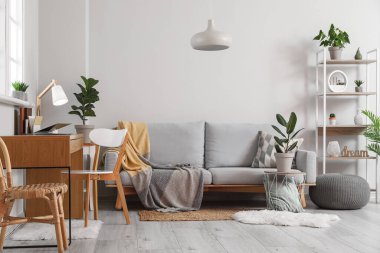 Kanepesi, işyeri ve çiçekleri olan şık bir oturma odası.