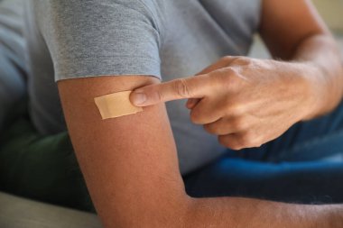 Evde nikotin bandı takmış olgun bir adam, yakın plan. Sigara içmeyi bırakma