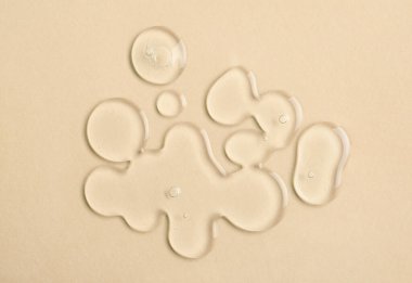 Renk arkaplanında kabarcıklar olan saydam sıvı jel damlaları