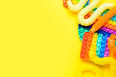 Renkli pop tüpleri ve patlayan oyuncaklar sarı arka planda