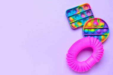 Renkli pop tüpü ve patlat Kıpır kıpır oyuncaklar mor arka planda