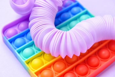 Renkli pop tüpü ve mor arka planda hareketli oyuncak