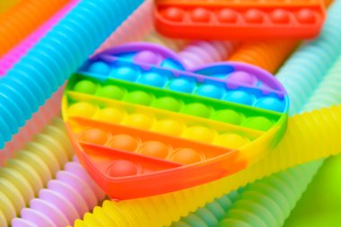 Renkli pop tüpleri ve patlayan oyuncaklar yeşil arka planda