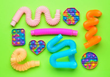 Renkli pop tüpleri ve patlayan oyuncaklar yeşil arka planda