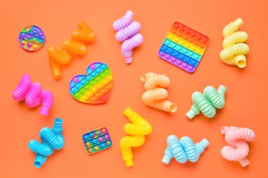 Renkli pop tüpleri ve turuncu arka planda hareketli oyuncaklar