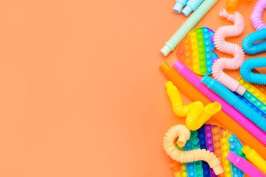 Renkli pop tüpleri ve turuncu arka planda hareketli oyuncaklar