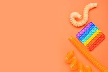 Renkli pop tüpleri ve turuncu arka planda hareketli oyuncaklar