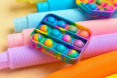 Renkli pop tüpleri ve patlayan oyuncaklar sarı arka planda