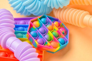 Renkli pop tüpleri ve patlayan oyuncaklar bej arka planda