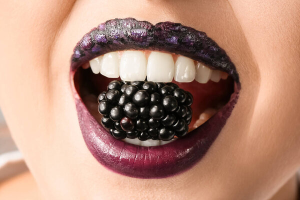 Beautiful young woman with unusual makeup and blackberry, closeup